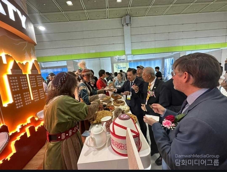 누르갈리 아르스타노프 주한 카자흐스탄 대사가 알마티시 부스에서 방문객들에게 전통 음식을 소개하고 있다.