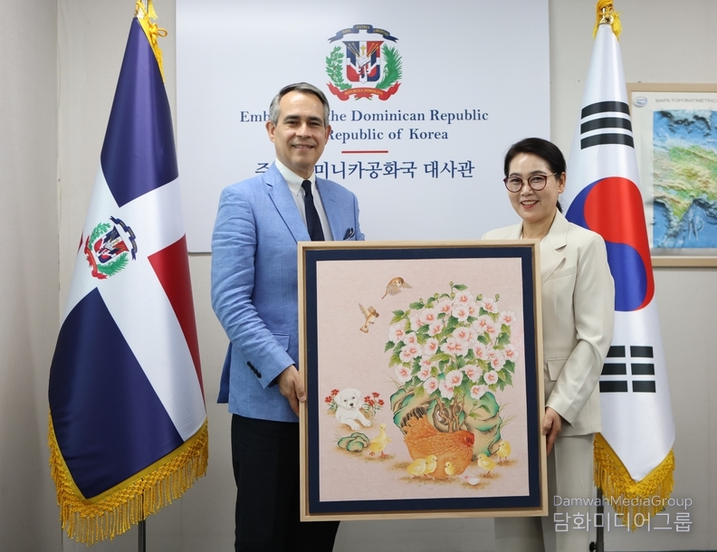 주한 도미니카 공화국 대사에게 작품을 기증하고 있다.